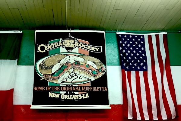 American flag and colorful sign at entry to Central Grocery before renovations.
