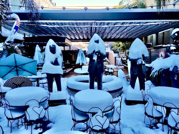 NOLA Should be Renamed SNOWLA!Trio of statues of famous NOLA musicians covered in snow, as well as tables and chairs piled with snow.