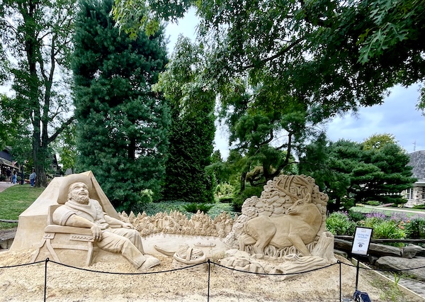 Front of one of the Sand Sculptures Peddler's Village depicts a man lounging in a chair and a deer in front of a leafy tree