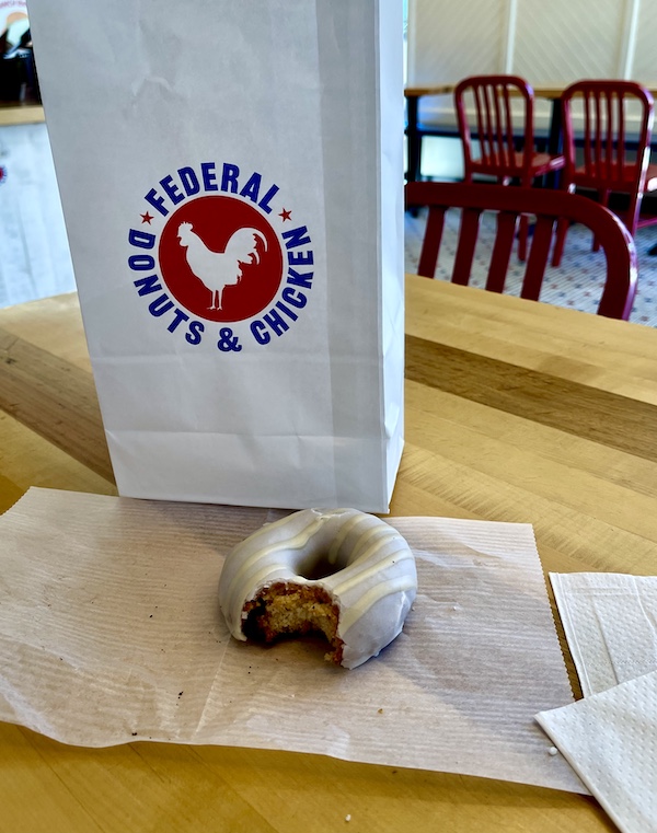White bag on a table with an iced donut at Federal Donuts on our Tour of Downtown Philadelphia