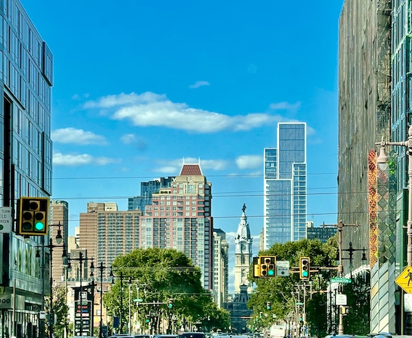 Cityscape with tall buildings trees and blue sky on our Tour of Downtown Philadelphia