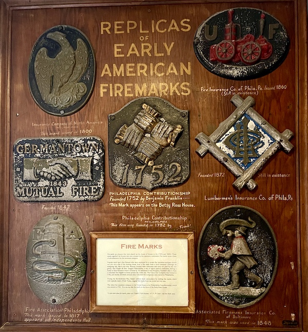 Large wooden wall hanging with assorted displaying Early American Firemarks 