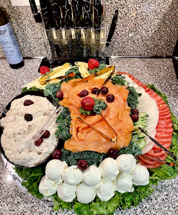 Platter of lox, veggies, cheeses, and cream cheese on a kitchen counter this Autumn.