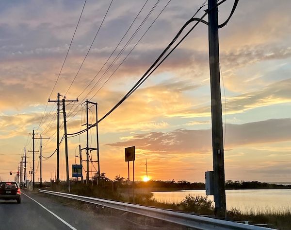 Colorful sky at sunset, electric poles and wires, paved street and bay all part of our Autumn Memories at Jersey Shore