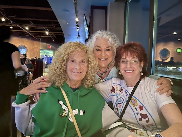 Three women at Basket lined with deli paper and filled with seasoned crinkle fries at Chickie's and Pete's Atlantic City restaurant.