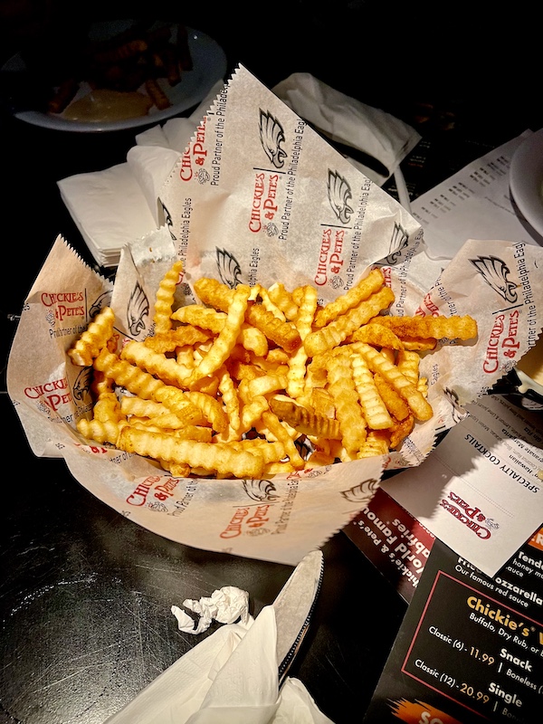 Basket lined with deli paper and filled with seasoned crinkle fries at Chickie's and Pete's Atlantic City