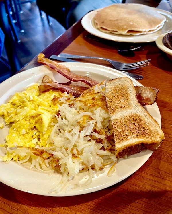 Beige plate topped with scrambled eggs, potatoes, bacon and toast at Jimmy's Family Restaurant Easley SC