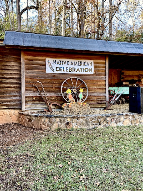 Banner on side of log home welcomes you to the Hagood Mill Native American Celebration