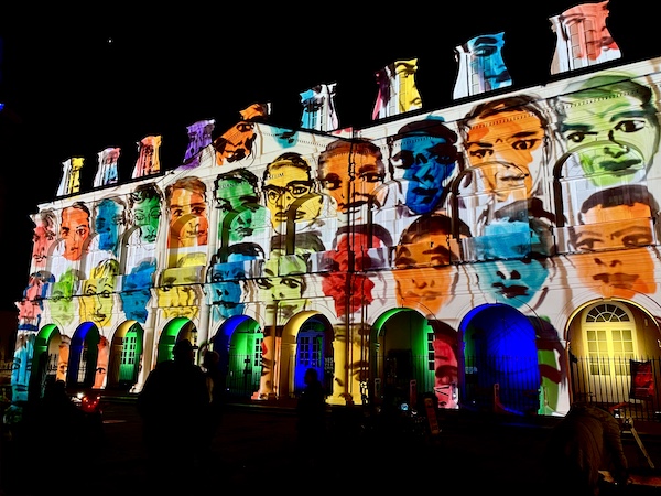 Colorful faces of men and women projected on a church for Celebrating Super Bowl NOLA Style