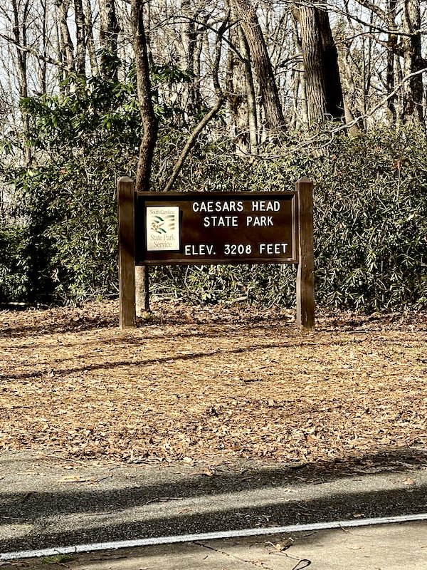 Brown wood sign with white letters welcoming you to Caesars Head State Park.