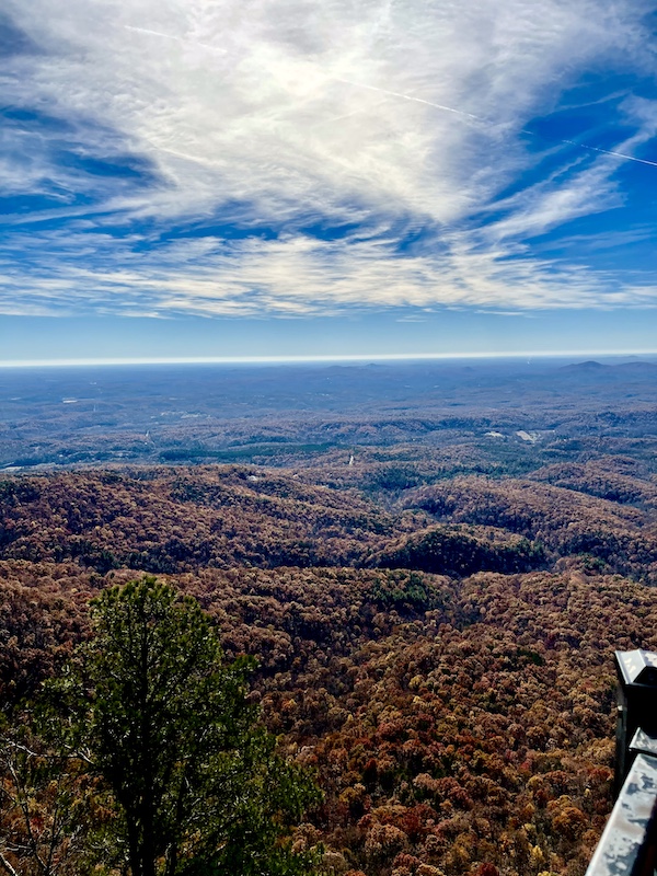 Rolling mountain vista with blue sky and puffy white clouds.
