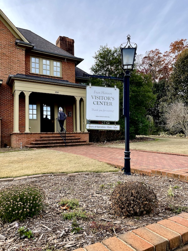 Red brick and wood trim building with slate roof and porch seen on our fSouth Carolina College Tour