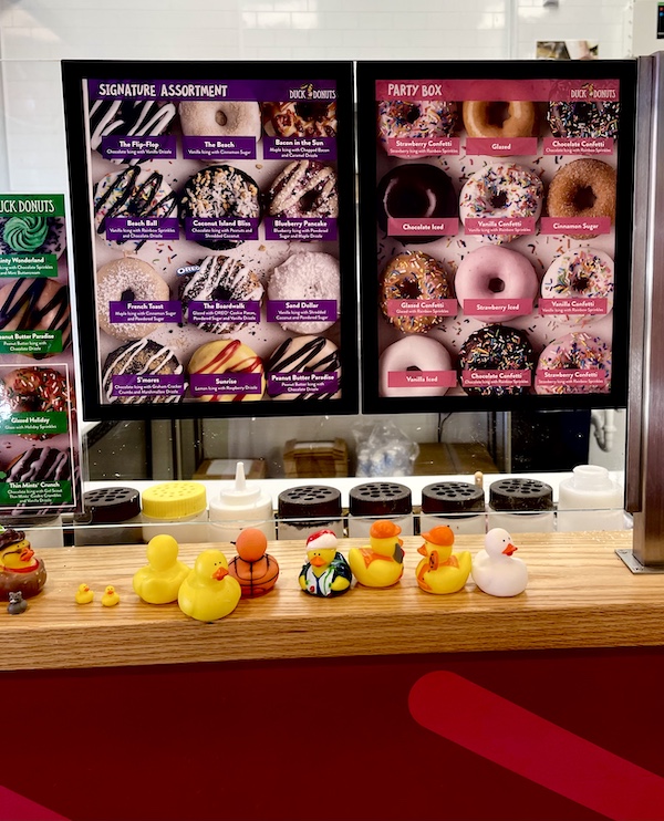 Duck donuts menu plus assorted rubber duckies on a counter seen while on our South Carolina College Tour