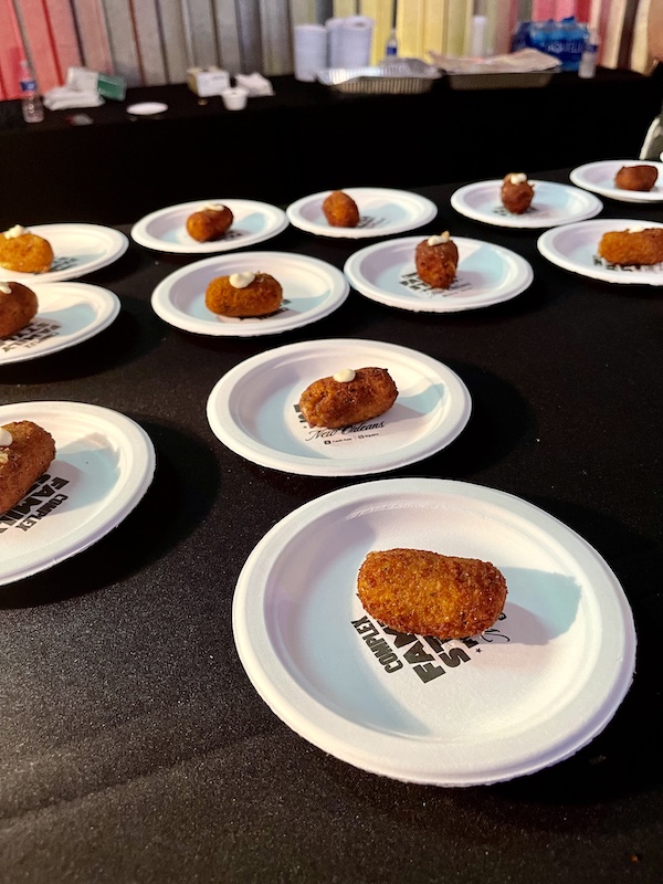 White plate topped with a golden brown croquette topped with a dollop of cream at Family Style FoodFest NOLA