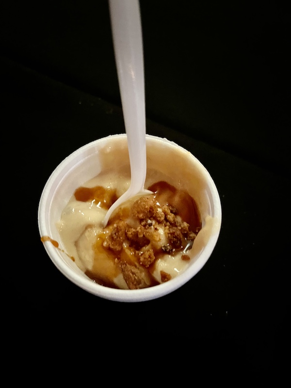 Bowl of bananas, pudding and caramel with while spoon sticking up at Family Style FoodFest NOLA