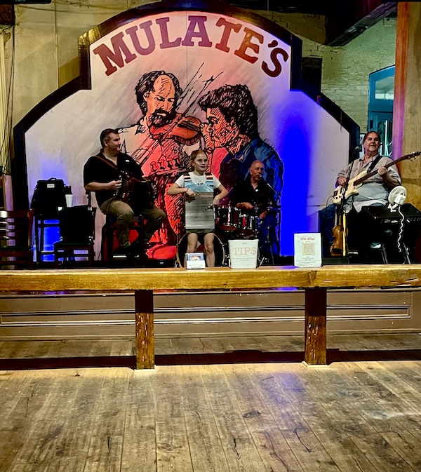 Inside Mulate's, the Original Cajun Restaurantwith a family playing instruments on a stage.