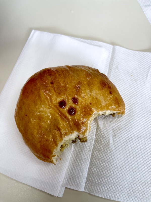 One of our Delicious Texas Kolaches sitting on a napkin with two bites eaten.