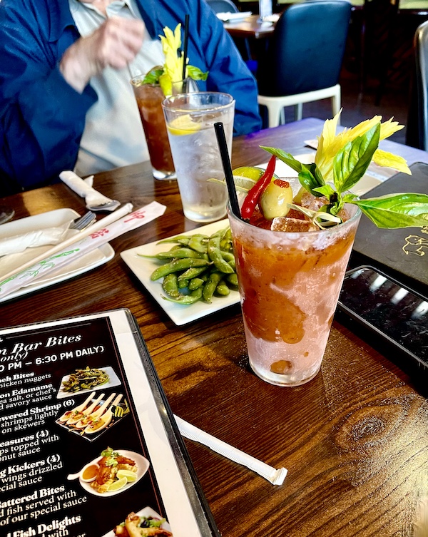 Menus on table at Thaicoon Restaurant Pearland Texas along with frosty glasses of bloody Marys with celery, olive and hot pepper garnish.