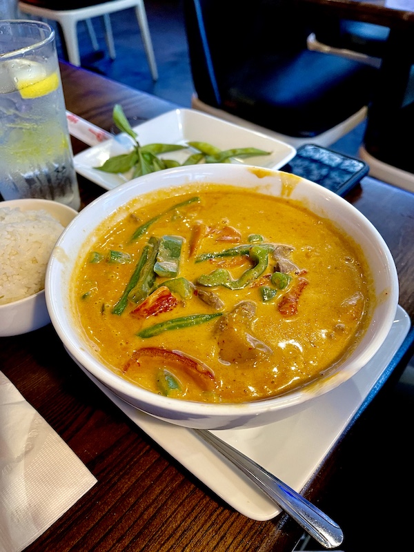 Bowl of orange curry sauce, pepper, green beans and beef at Thaicoon Restaurant Pearland Texas