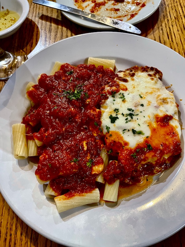 Plate topped with veal parmesan, red sauce and rigatoni pasta at Italian Garden Restaurant Canyon Lake TX