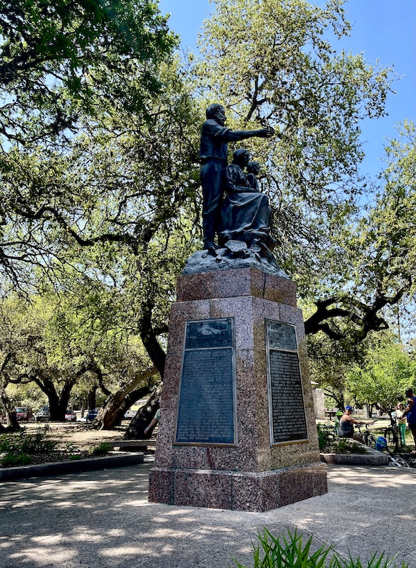 Bronze sculpture of a family atop pillar pedestal in Landa Park New Braunfels TX