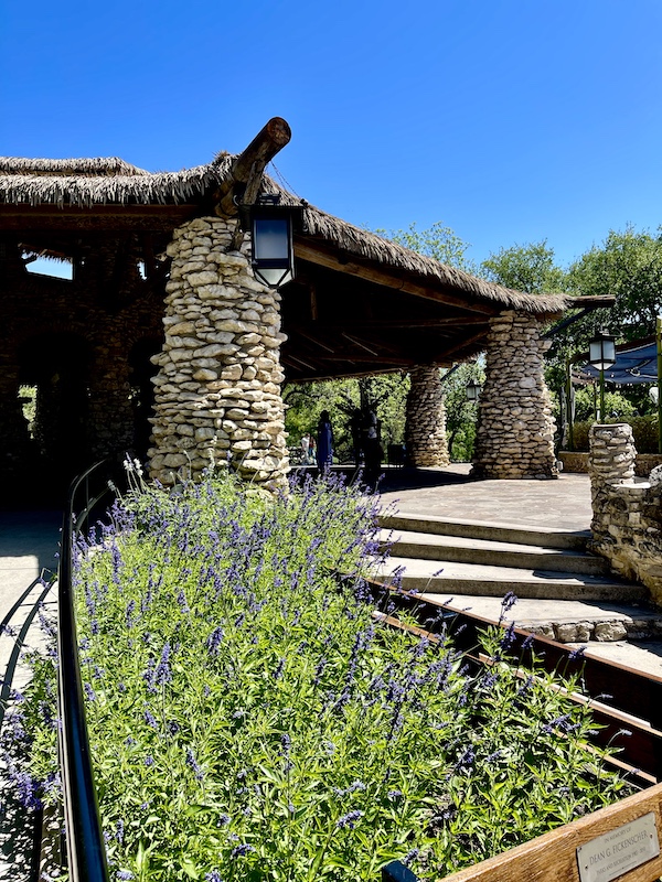 Purple flowers in front of limestone and wood pagoda at Japanese Tea Garden San Antonio
