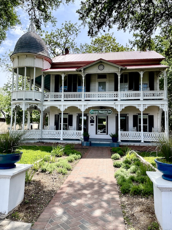 Ornate white inn with balconies and red roof in Gruene Texas