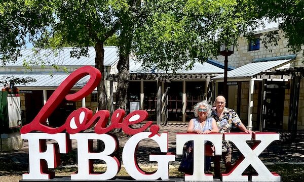 Steve and I standing behind a large sign with white letters FBGTX.