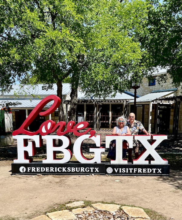 Steve and I standing behind a large sign with white letters FBGTX.