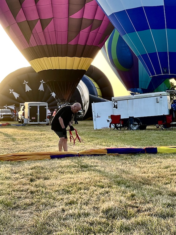 Steve bending over a rolled up hot air balloon at the Hopkins County Dairy Festival 2025