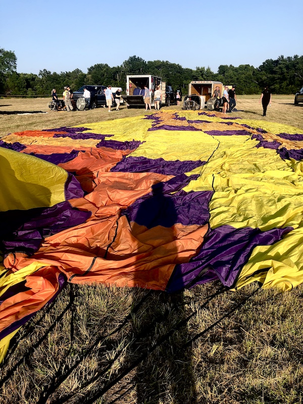 Yellow, orange and black hot air balloon being stretched out at the Hopkins County Dairy Festival 2025
