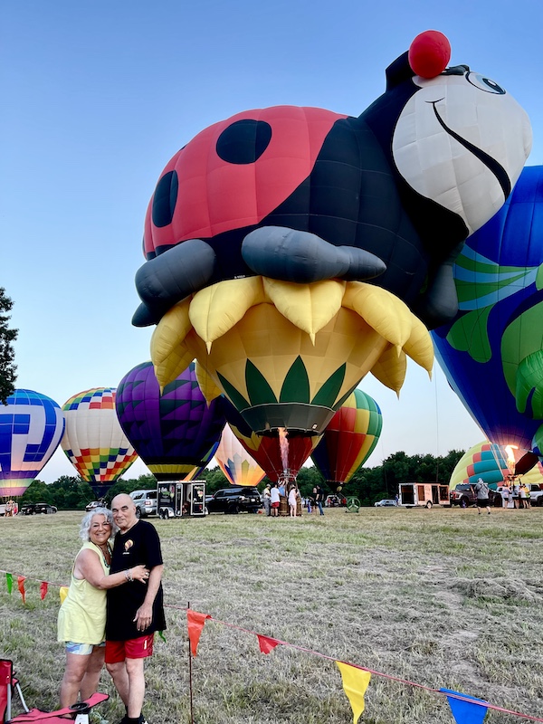 Steve and I standing in front of a huge Ladybug balloon at the Hopkins County Dairy Festival 2025