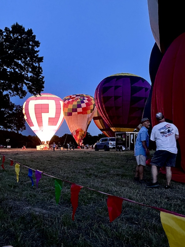 Tethered hot air balloons glowing with light at the Hopkins County Dairy Festival 2025
