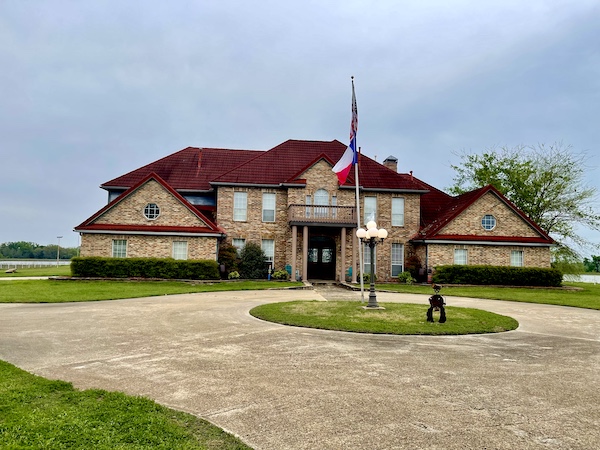 Large tan home with dark red roof and circular driveway is where we stayed while having June Fun in Sulphur Springs TX