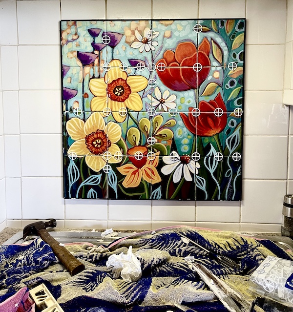 Colorful flower mosaic with round white spaces in place before grouting during the Kitchen Transformation in Texas