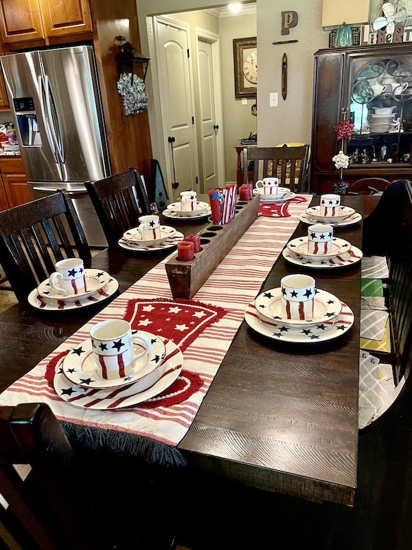 Ranch house dark wood dining table set with table runner and dishes all with red white and blue stars and stripes where we visited Texas Longhorns Up Close