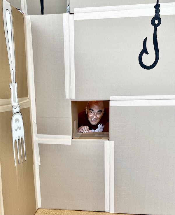 Steve's head peaking through a window in the Art Maze at Westmoreland Museum of American Art 2. A painted fish hook and fork are also in the photo.