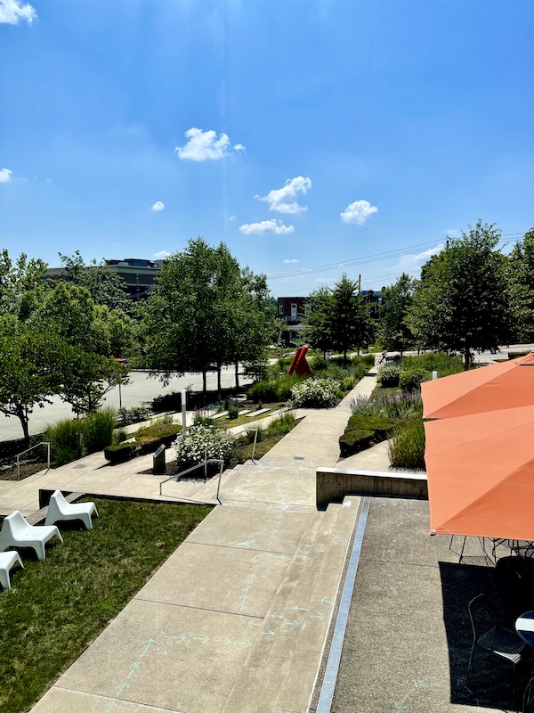 View of gardens and orange market umbrellas through window at the Westmoreland Museum of American Art