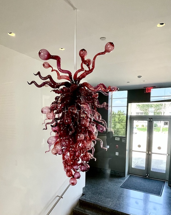 Burgundy colored blown glass pendant sculpture hanging from ceiling in the Westmoreland Museum of American Art