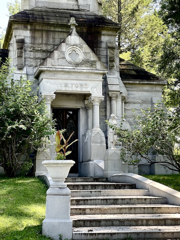 White ornate mausoleum with columns stairs and tall planters at Allegheny Cemetery Pittsburgh Pennsylvania