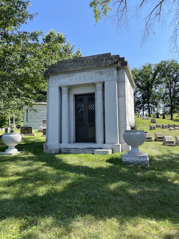 Greek revival style mausoleum with dark roof on lawn at Allegheny Cemetery Pittsburgh Pennsylvania