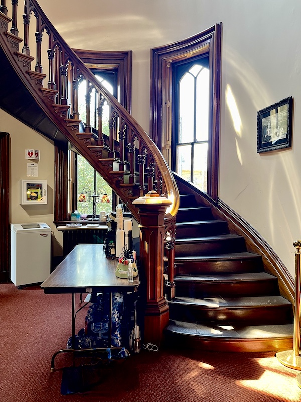 Curved grand staircase of dark mahogany wood in main building of Allegheny Cemetery Pittsburgh Pennsylvania
