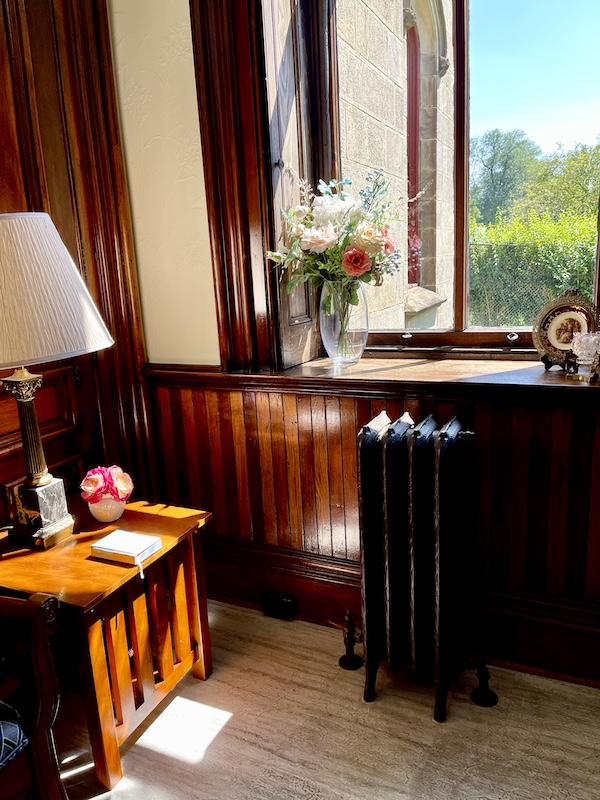 Large window, wood tables and vases of flowers adorn the ladies room at Allegheny Cemetery Pittsburgh Pennsylvania