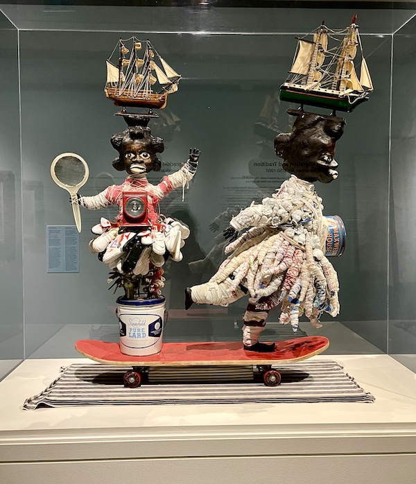 Two sculptures of black women on one red skateboard, both with sailing ships on their heads at Allentown Art Museum