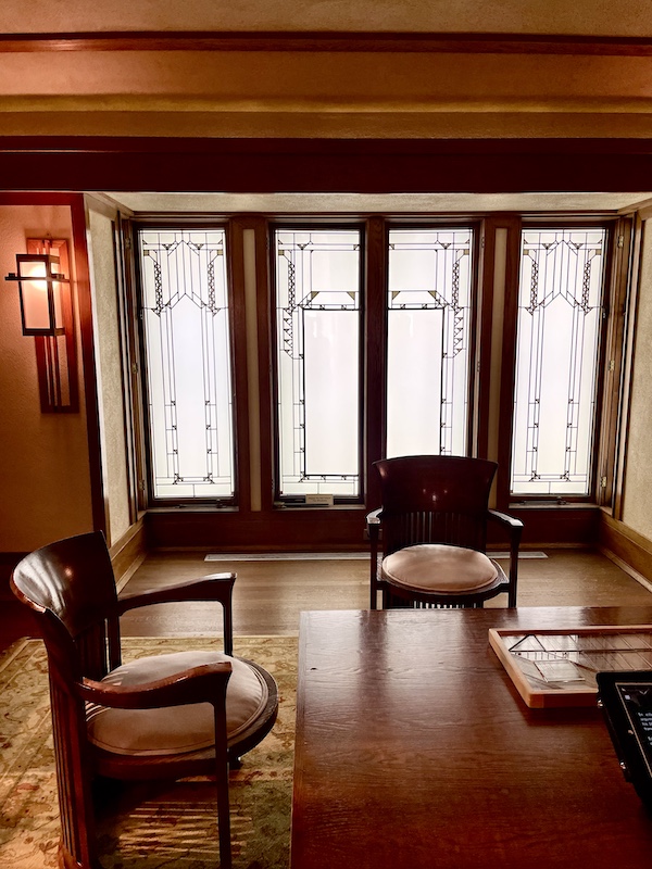 Wood table, chairs and walls, leaded glass doors and area rug at Allentown Art Museum