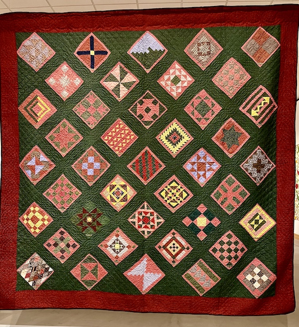 Multicolored quilt made of tiny squares with each square containing a small stamped name at Allentown Art Museum Quilts