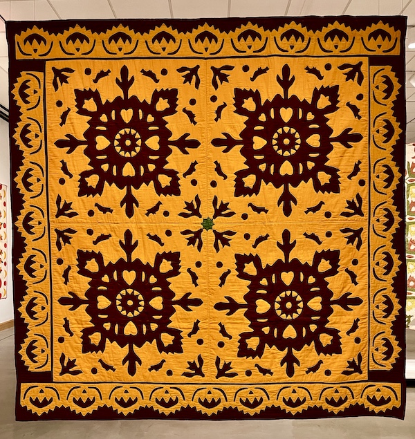 Orange and burgundy with lacy design quilt at Allentown Art Museum Quilts
