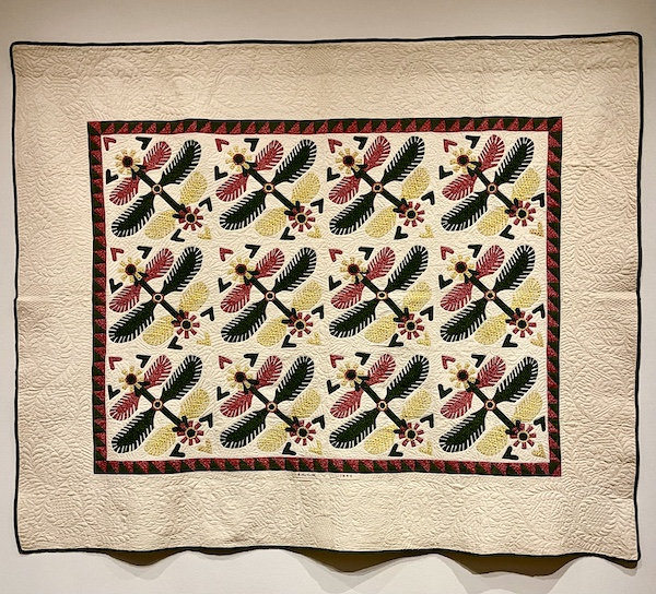 Ivory, olive green and red quilt of dragon flies at Allentown Art Museum Quilts