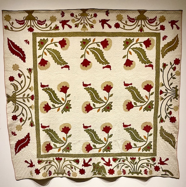 Off white, dark red, gold and olive green floral quilt with birds at Allentown Art Museum Quilts
