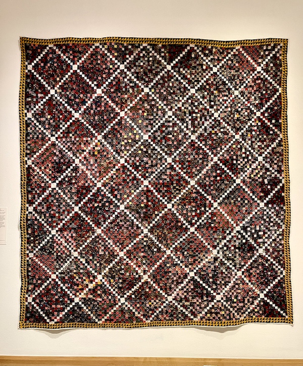 Multicolored quilt in a diamond pattern made up of tiny squares of fabric at Allentown Art Museum Quilts